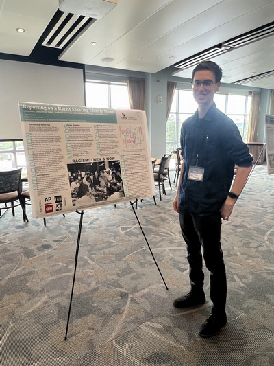 Student standing next to his poster at DHI Showcase