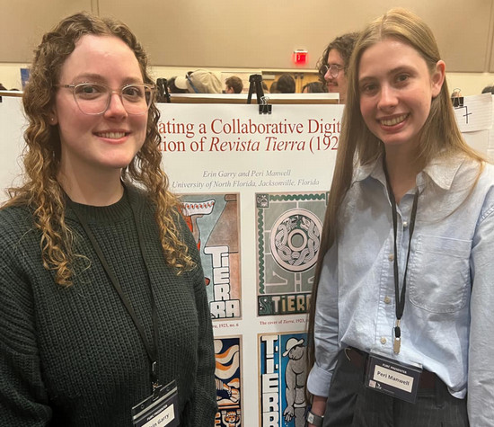 Two students stand in front of their poster 