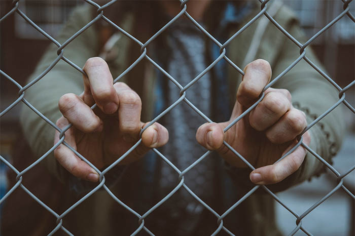 Closeup of hands holding a fence