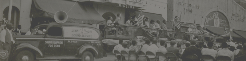 Photograph of people celebrating in front of a building