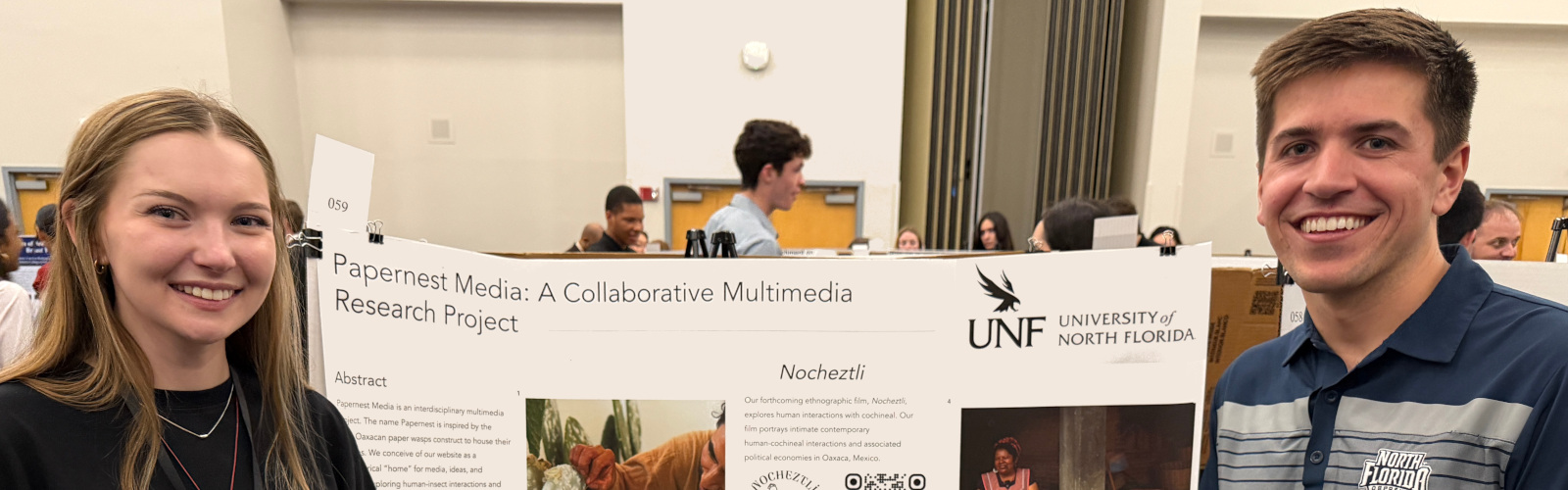 Two students standing in front of a research poster
