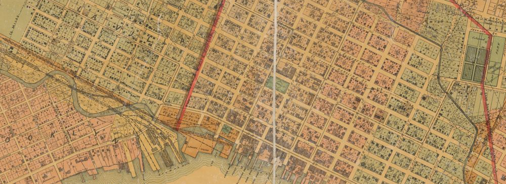 A detail of an old map of city streets with a section of waterfront wharves