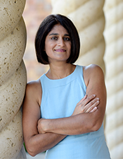 Headshot photo of Neera Shetty standing next to a column.