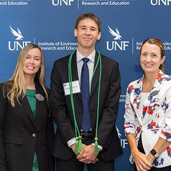 Three individuals standing for a professional award photo.