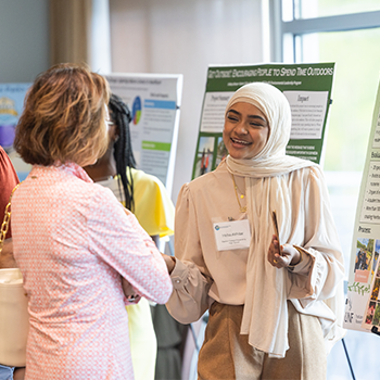 Two individuals discussing a poster displayed.