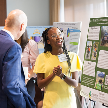 Two individuals discussing a poster displayed.