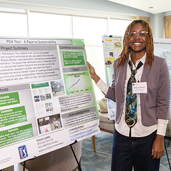 Individual standing next to poster on display.