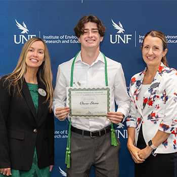 Three individuals standing side by side for award photo.