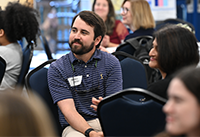 Brazos Barber sitting at table listening to presentation at ELP Symposium.