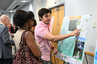 ELP student presenting his poster to a community partner at the symposium.