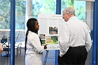 ELP student presenting her poster and project to a Community Council member.