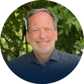 Headshot of Dr. Marc Berejka with blurred nature background.