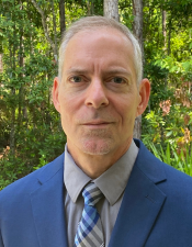 Headshot of Kerry Clark, Ph.D. in nature background.