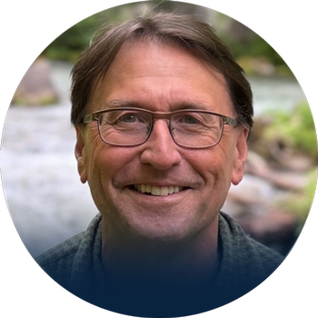 Headshot photograph of Roger Still with nature background.