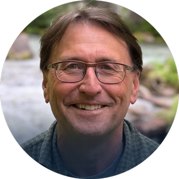 Headshot of Roger Still with nature background.