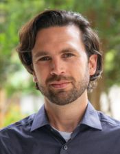 Headshot of Will Pewitt, Ph.D. with nature background.