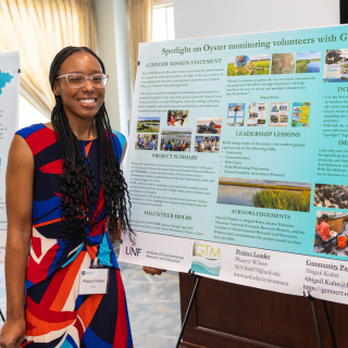 Person presenting a poster on oyster monitoring project.