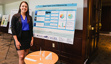 Student standing with poster