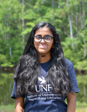 Headshot of Kumud with trees behind her.