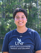 Headshot of student standing outdoors with nature background.