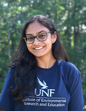 Headshot of student standing outdoors with nature background.