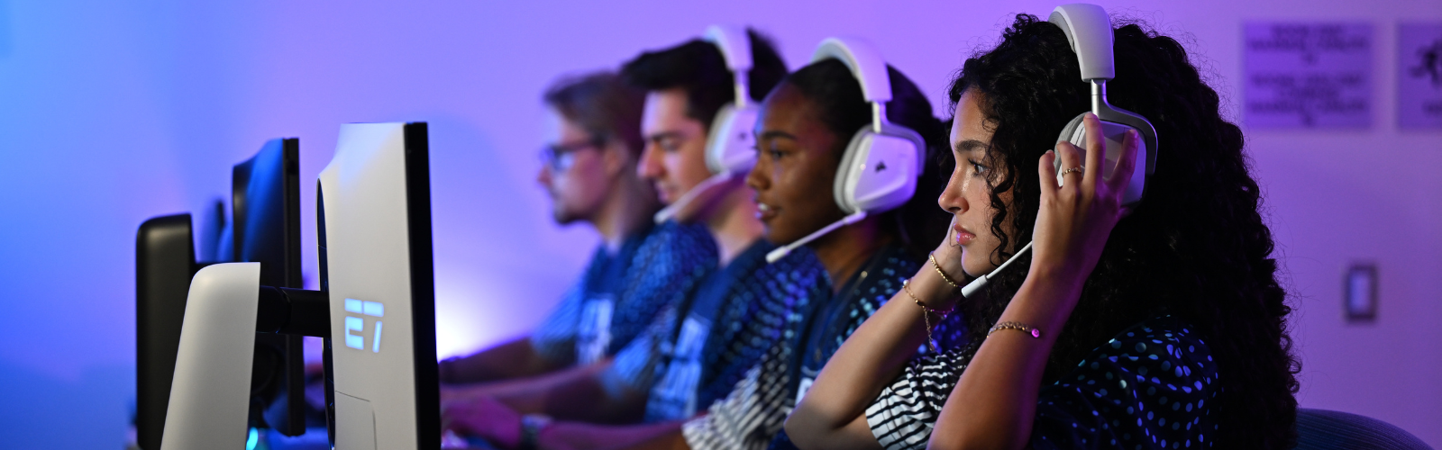 Team of 4 UNF students at their monitors with headphones on
