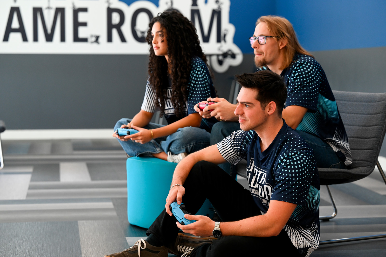 Three students playing on controllers
