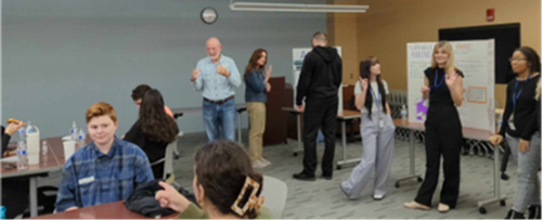 UNF students showing posters of their work to community members.