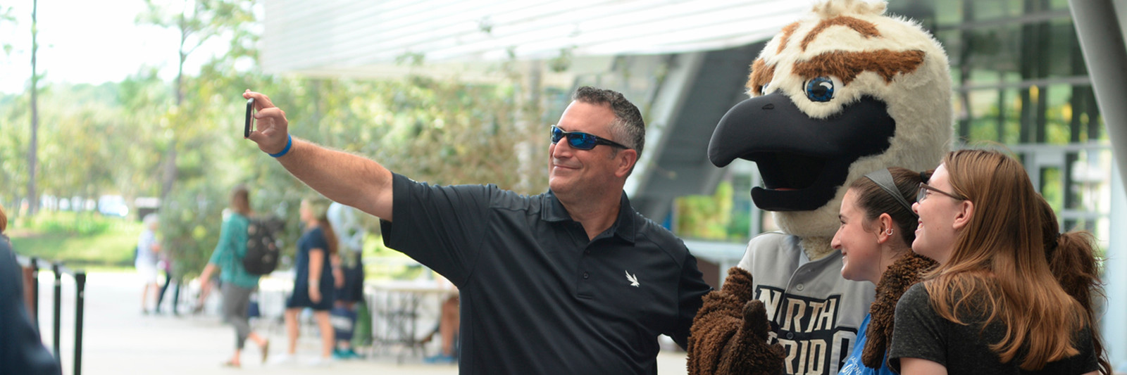 A man taking a selfie with Ozzie and three women