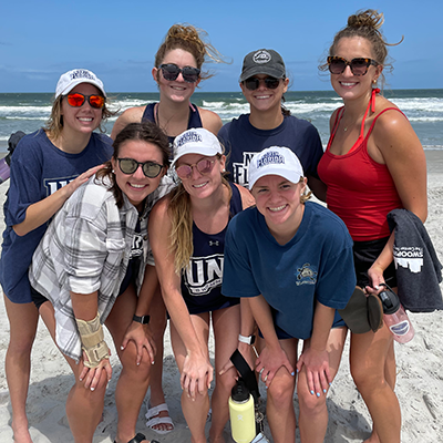 seven girls posing at beach after beach clean up