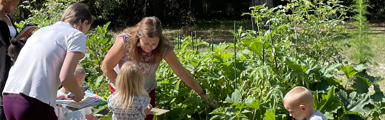 Family Garden Facilitator at center playing scavenger hunt. 
