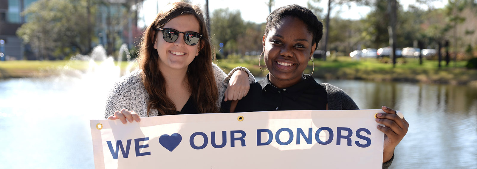 two students holding we love our donors banner