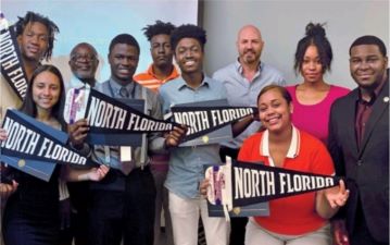 students holding up north florida pendants