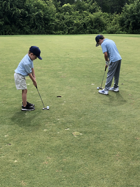 two boys putting on a green