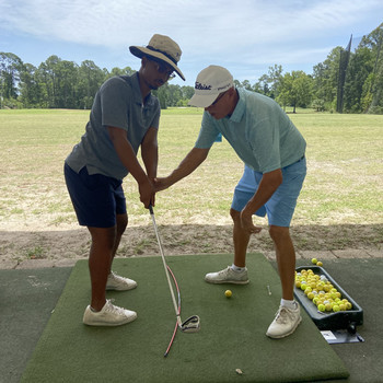 golf instructor and student on driving range
