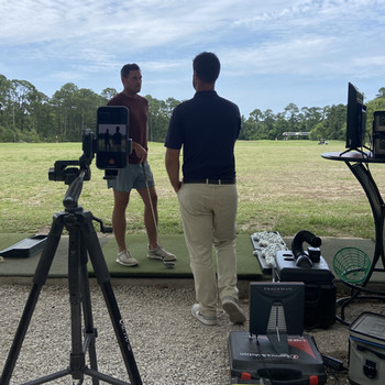 golf instructor and student on driving range