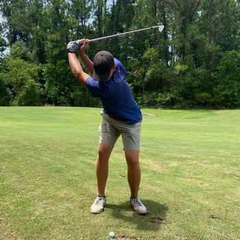 golf player on range swinging golf club