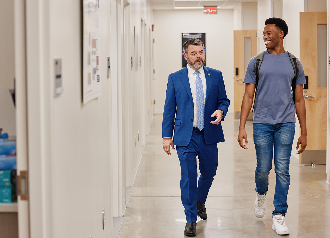 Student and Professor walking down a hallway chatting