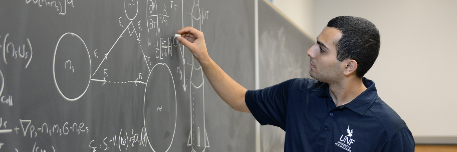 UNF student solving equations on a chalkboard
