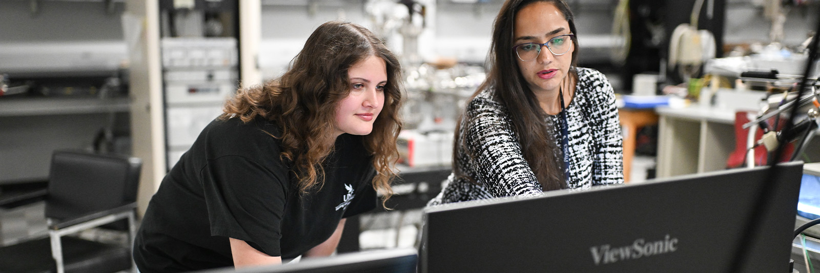 Student and Professor looking at computer screen in lab