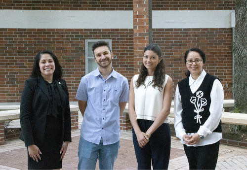 Raphaela Macanas, Amar Kosovac, Sophia Cochran and Syeda Hyder smiling together outdoors in front of a brick building.