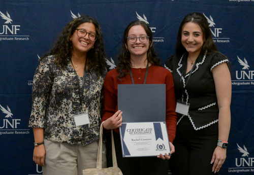 Three women posing with Certificate of Excellence
