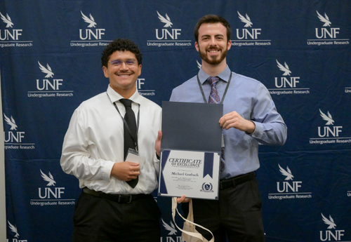 Two men posing with Certificate of Excellence
