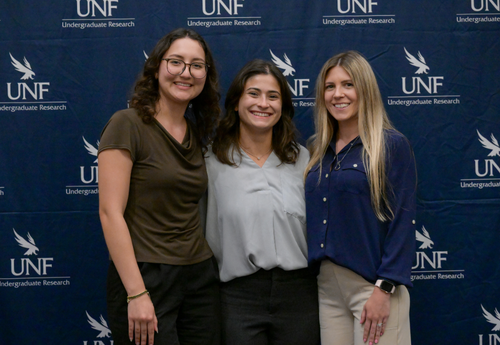 Three women smiling at UNF Student Research Symposium