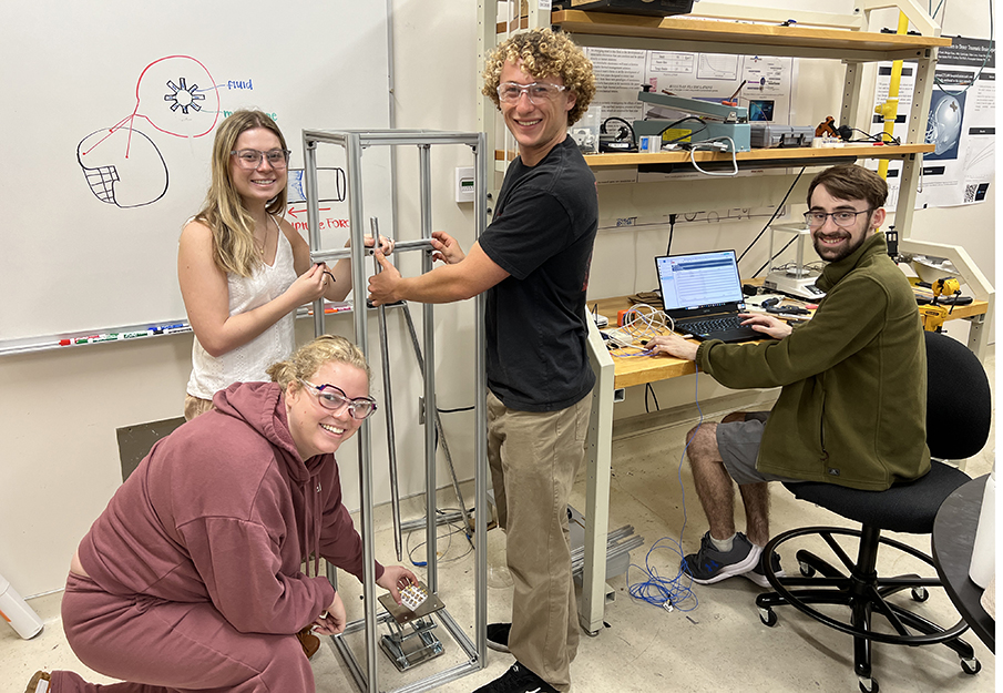 UNF undergraduate students Bridget Dunn, Abby Kuba, Ethan Lowe and graduate student Gabriel Pesek working with equipment