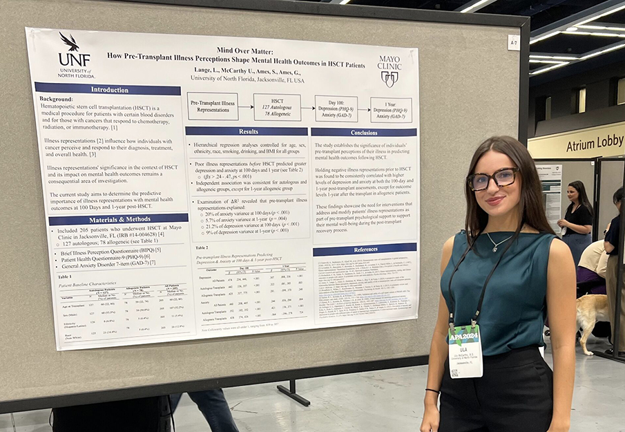 Ula McCarthy standing by her research poster