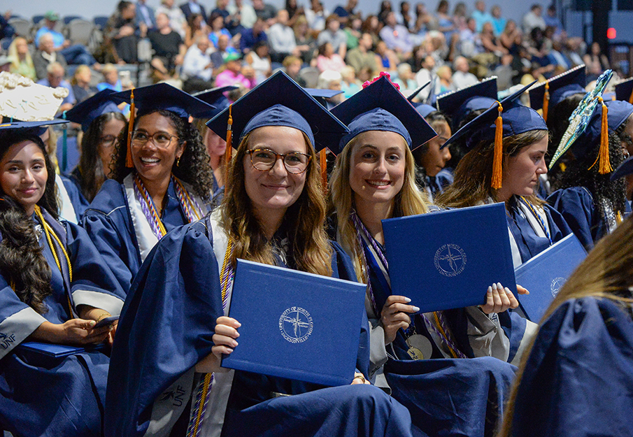 UNF students sitting with other graduates