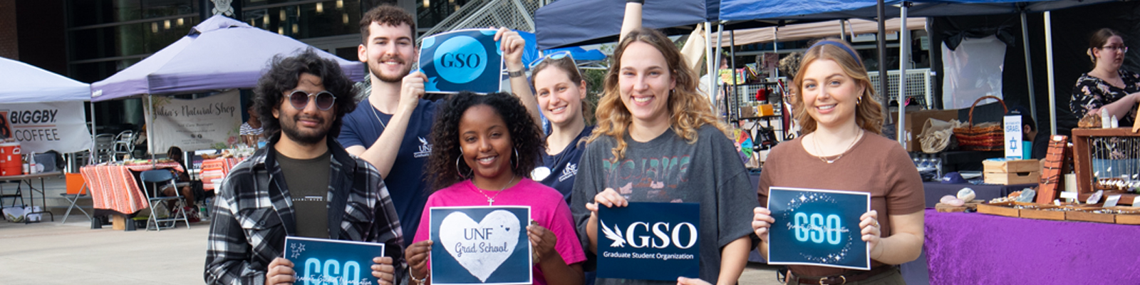 grad student organization students holding GSO signs at market days