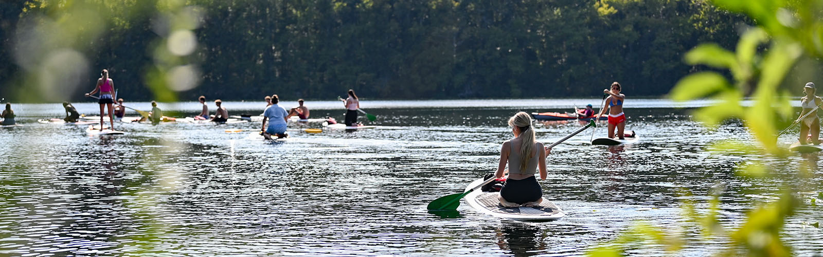 students doing yoga on paddle boards at Lake Oneida