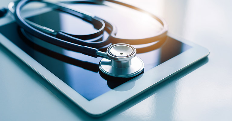 stethoscope on top of a computer tablet